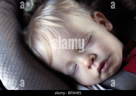 Babyjungen schlafen im Autositz. 12 Monate alt. Stockfoto