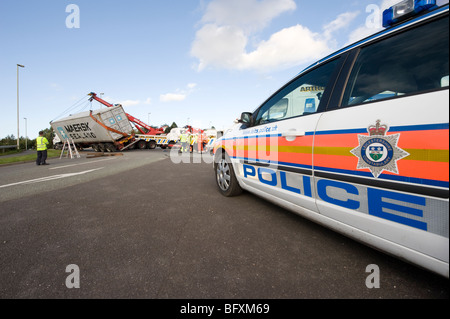 Umgestürzter LKW gerettet von einem Rettungs-Lastwagen in Leicestershire, England mit Polizeiwagen vor Ort Stockfoto