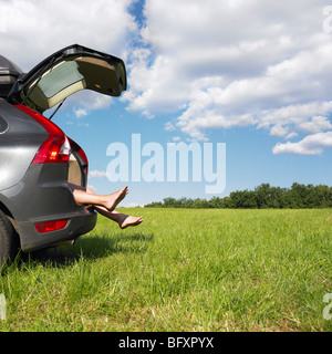 Füße aus Kofferraum hängen Stockfoto