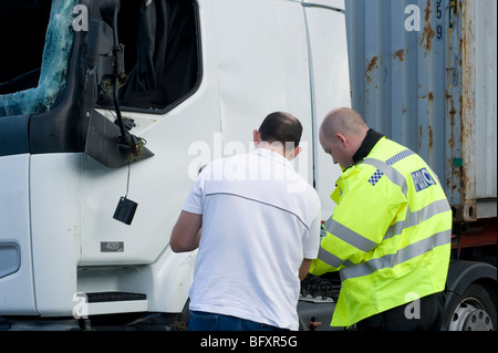 Polizisten, die Befragung eines Zeugen nach einem LKW-Unfall auf einer englischen Straße. Stockfoto