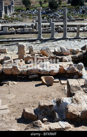 Überreste von Gebäuden neben antiken Säulen, die Linie die Kolonnade in den Ruinen von Patara Stockfoto