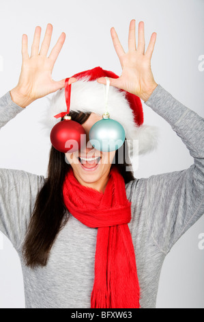 Frau für Augen mit Christbaumschmuck Stockfoto
