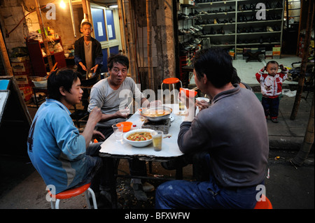 Chinesischer Wanderarbeiter Essen zusammen in einem kleinen Restaurant in Shanghai, China. 13. Oktober 2009 Stockfoto