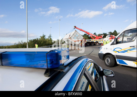 Umgestürzter LKW gerettet von einem Rettungs-Lastwagen in Leicestershire, England mit Polizeiwagen vor Ort Stockfoto