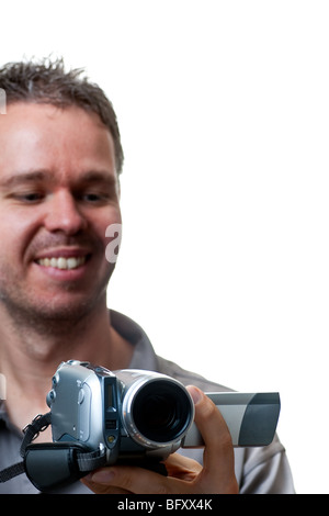 Ein lächelnder Mann schießen mit einer Videokamera, Fokus auf die Video-Kamera, isoliert auf weiss. Stockfoto
