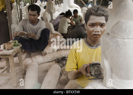 Ein Stein Handwerk Mann Bildhauerei einen Buddha-Kopf in einer Werkstatt in Mandalay Stockfoto