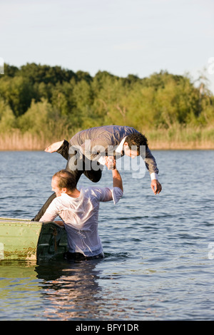 Geschäftsmann werfen Freund im Wasser Stockfoto