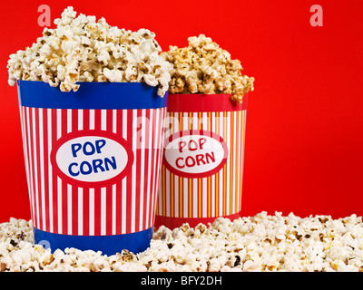 Zwei Popcorn-Eimer auf einem roten Hintergrund. Stockfoto