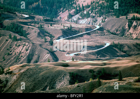 Cariboo Chilcotin Region, BC, Britisch-Kolumbien, Kanada - Farwell Canyon Road, ländlichen Rennstreckenareal schlängelt sich durch robuste Badlands Stockfoto