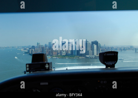 Eine Cockpitansicht leichte Flugzeug Cessna 172 fliegende Front von Lower Manhattan, East River und Hudson River, New York City, USA Stockfoto