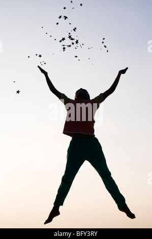 Silhouette eines kleinen indischen jungen springen und Wurfsterne bei Sonnenuntergang. Indien Stockfoto