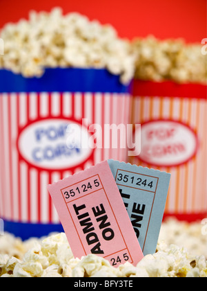 Zwei Popcorn-Eimer auf einem roten Hintergrund. Film-Stubs sitzen über das Popcorn. Stockfoto