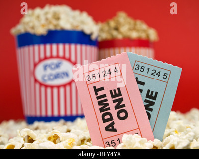 Zwei Popcorn-Eimer auf einem roten Hintergrund. Film-Stubs sitzen über das Popcorn. Stockfoto