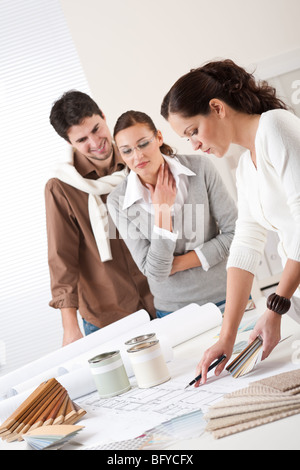 Junge erfolgreiche interior Designer Frau mit zwei Clients im Büro, die Auswahl der Farben Stockfoto