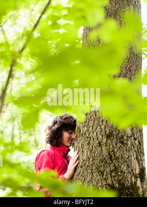 Frau umarmt Baum Stockfoto