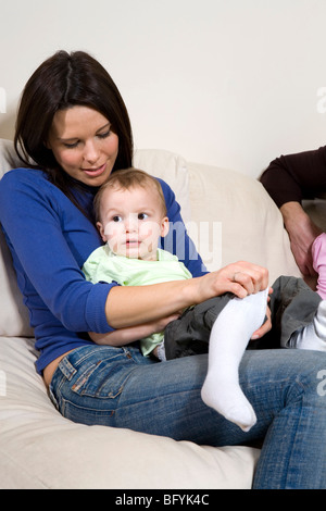 Mutter mit ihrem Baby Sohn auf dem Sofa sitzen Stockfoto