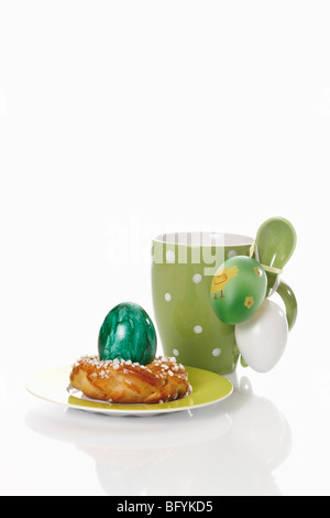 Kaffeebecher mit kleinen Savarin und Easter eggs Stockfoto