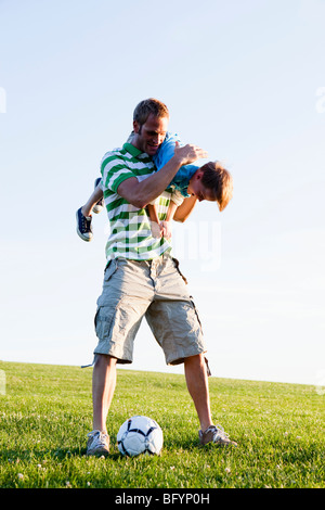 Vater mit Sohn auf Schulter Stockfoto