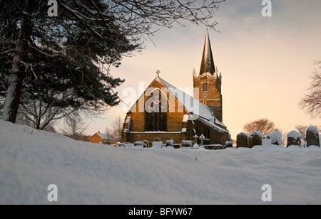 Eine verschneite Szene zeigt die Pfarrei Kirche des St. Catherines bei Barmby in East Riding of Yorkshire. Stockfoto