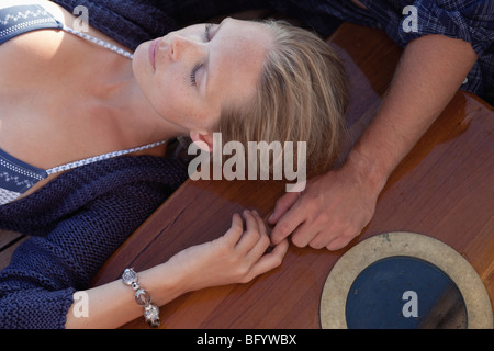 paar auf Deck Hand in Hand liegend Stockfoto