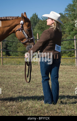 Hübsche blonde Frau im Wettbewerb der Extraklasse Halfter bei einem kleinen Land Horse Show. Stockfoto