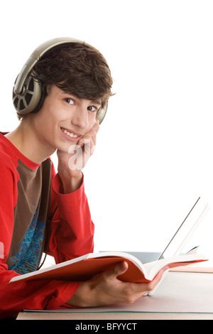 Teenager sitzen hinter Schreibtisch Buch lesen und hören Musik isoliert auf weißem Hintergrund Stockfoto