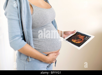 Schwangere Frau Holding Sonogramm Stockfoto