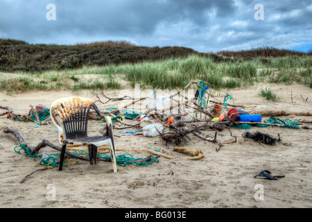 Mischung aus bunten Müll, Seile und Treibholz, die an einem Strand angespült wurde und gestapelt zusammen an Pembrey, Wales Stockfoto