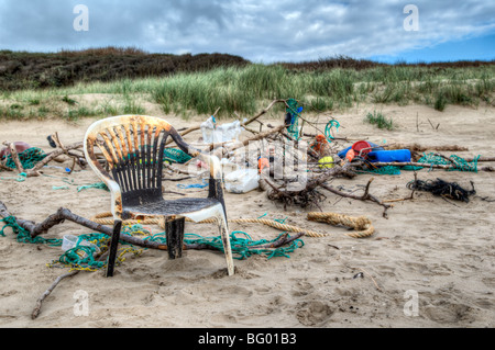 Mischung aus bunten Müll, Seile und Treibholz, die an einem Strand angespült wurde und gestapelt zusammen an Pembrey, Wales Stockfoto