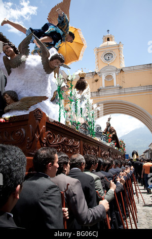 Prozession zu Ehren der Jungfrau Maria während der Semana Santa in Antigua Guatemala. Cucuruchos den Schwimmer auf ihren Schultern tragen. Stockfoto