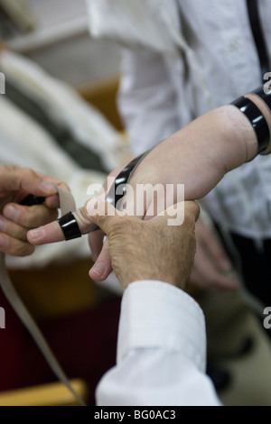 Bar Mizwa Junge Verlegung Tefillin (Gebetsriemen) während der Zeremonie Stockfoto