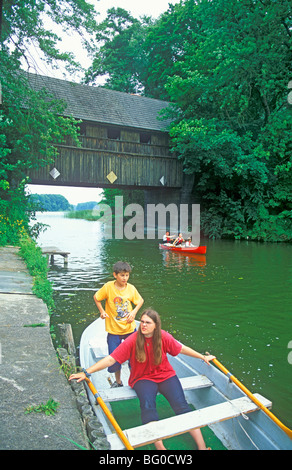 Kinder in ein Boot vor dem Haus-Brücke in Wesenberg-Ahrensberg, Mecklenburg-Vorpommern, Norddeutschland Stockfoto