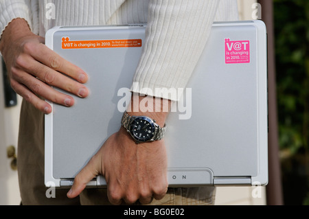 MwSt-Änderungen für 2010 Mann mit Laptop-Computer mit Erinnerung auf MwSt-Änderungen-Aufkleber Stockfoto