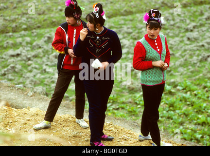 Drei junge Miao-Frauen auf einem Festival in einem kleinen Dorf in der Nähe von Kaili in der Provinz Guizhou, China Stockfoto