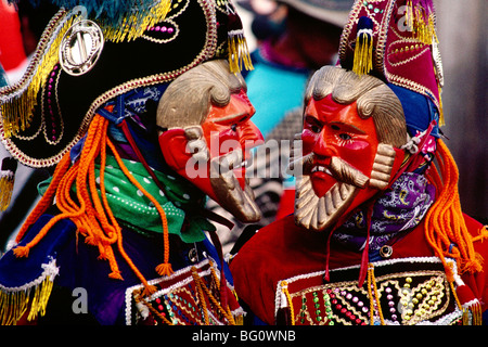 Zwei Teilnehmer Masken tragen, die die Spanischen Eroberer über die Maya haben ein Gespräch während der jährlichen August Festival in Joyabaj, Guatemala Stockfoto