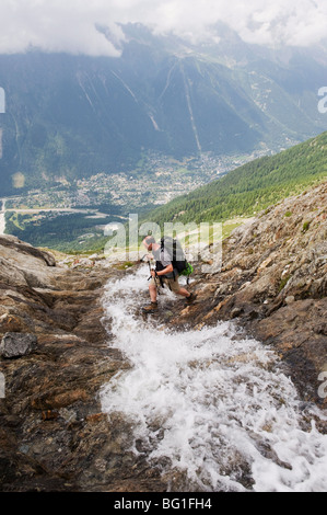 Wanderer, die über einen Bach über dem Tal von Chamonix, Rhone Alpes, Frankreich Stockfoto