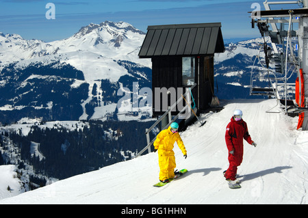 Snowboarder, die Ankunft an der oberen Chamossiere Sesselbahn Station im Skigebiet Morzine Avoriaz, Haute-Savoie, Frankreich Stockfoto