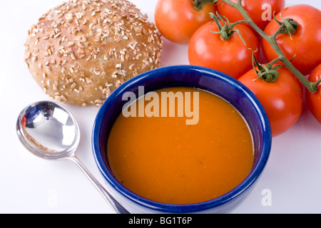 Gebratene Paprika und Tomaten Suppe mit Brötchen und Tomaten am Weinstock. Stockfoto