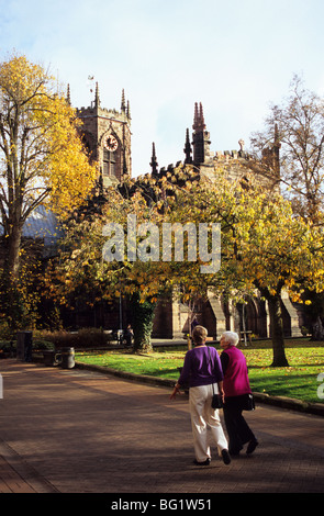 Zwei ältere Damen, die zu Fuß In Nantwich Town Centre In Cheshire in der Nähe der Marienkirche Stockfoto