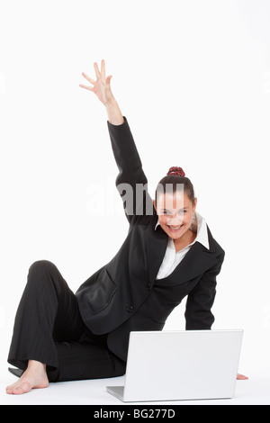 junge schöne Geschäftsfrau sitzen vor ihrem Laptop jubeln Stockfoto