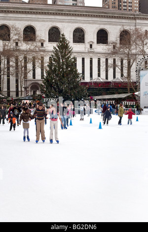 Multikulturelles Publikum genießt Verriss auf Bryant Park Teich vor dem Hintergrund der temporären Weihnachten Geschäfte & großen geschmückten Baum Stockfoto