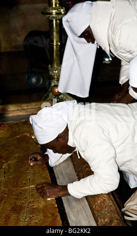 Afrikanische Schwestern beten vor dem Stein der Salbung, auch bekannt als der der Stein der Salbung in der Kirche des Heiligen Grabes Stockfoto