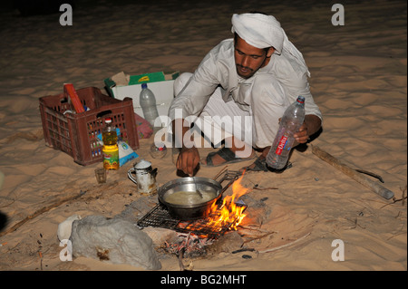 Beduinen-Männer kochen Mahlzeit in der Wüste über Feuer in der Nacht auf Wüste wandern Ausflug, Sinai, Ägypten Stockfoto