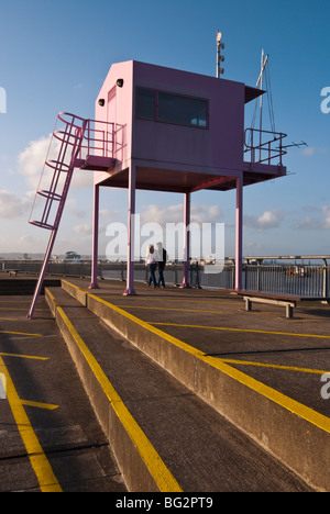 Menschen zu Fuß unter dem rosa Wachturm an der Cardiff Bay, South Wales UK Stockfoto