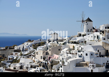 Traditionelle Häuser und Windmühlen im Dorf Oia unter späten Nachmittag Licht, Santorin, Griechenland Stockfoto