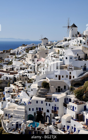 Traditionelle Häuser und Windmühlen im Dorf Oia unter späten Nachmittag Licht, Santorin, Griechenland Stockfoto