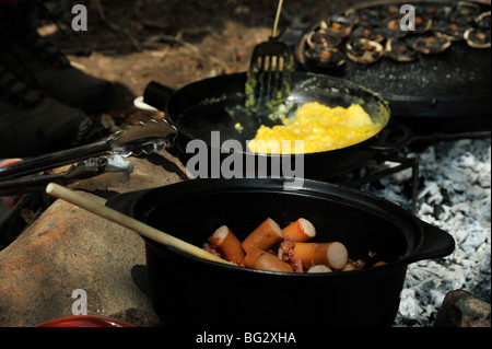 Szene der Kochtöpfe mit Rührei und Würstchen am Lagerfeuer Essen Reisen Südafrika Frühstück Stillleben Stockfoto