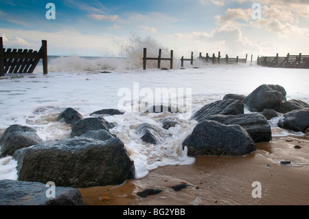 Wellen schlagen einen Wellenbrecher auf Norfolk Küste bei Happisburgh Stockfoto