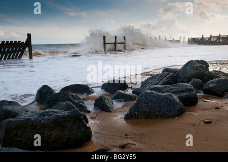 Wellen schlagen einen Wellenbrecher auf Norfolk Küste bei Happisburgh Stockfoto