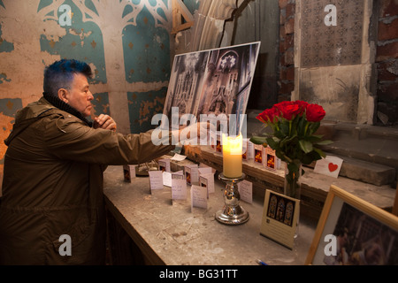 Großbritannien, England, Manchester, Gorton Kloster, Kirche und Kloster des Heiligen Franziskus, Mann liest Gebetskarten auf altar Stockfoto